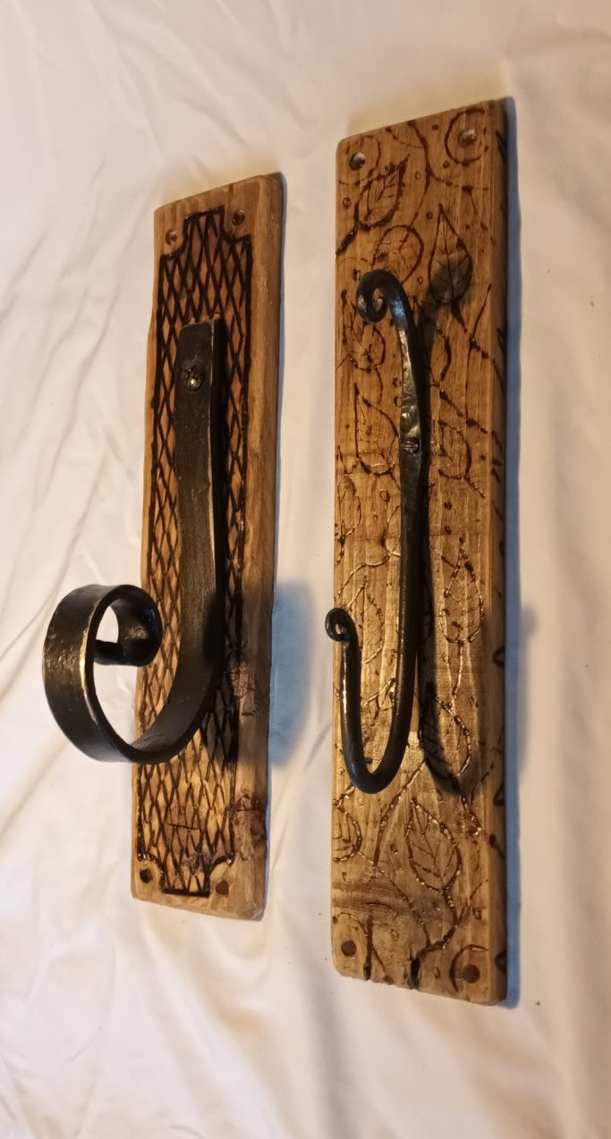 Hand forged metal hooks mounted on wood with pyrography drawings